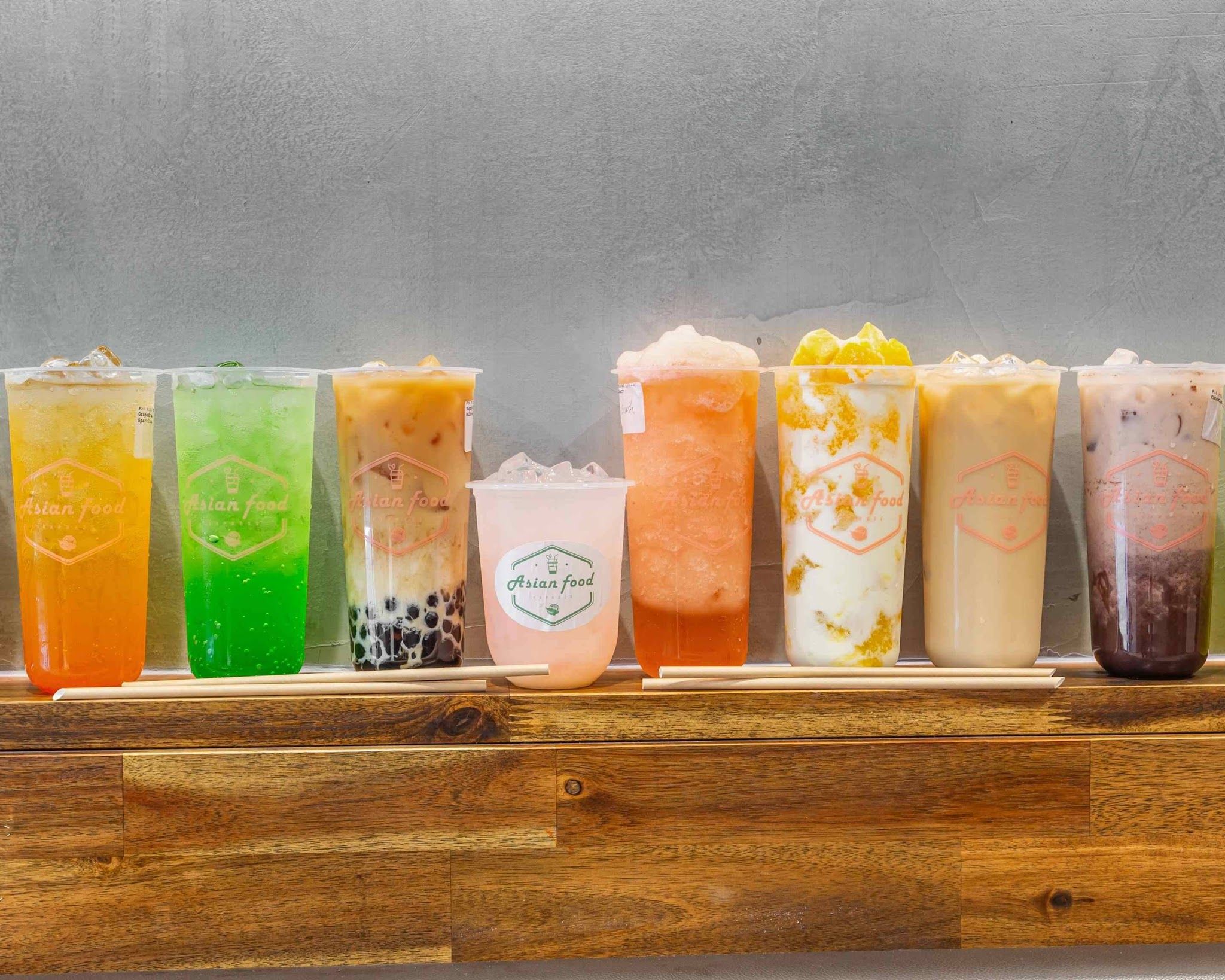 Row of eight colourful Asian Food Express bubble teas on wood counter